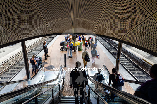 Commuters descending escalators to a train platform. Copenhagen Central Train Station, Copenhagen, Denmark.