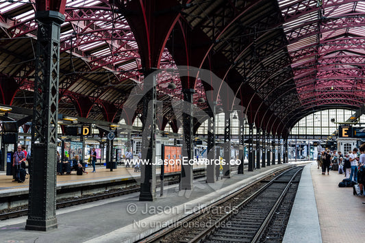 The steel and glass vaulted ceiling above a train platform. Copenhagen Central Train Station, Copenhagen, Denmark.