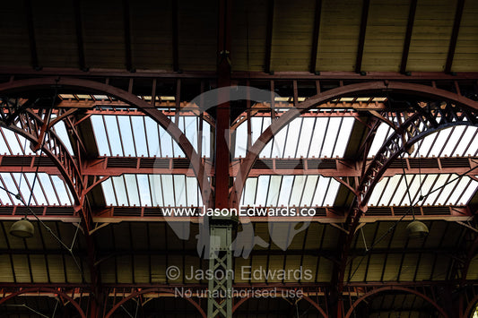 The steel and glass vaulted ceiling above a train platform. Copenhagen Central Train Station, Copenhagen, Denmark.