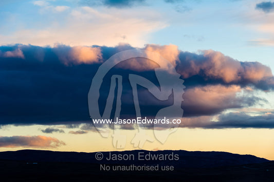 A low cloud bank hovers over a ridge in the arctic. Sugarloaf Mountain, Kangerlussuaq, Qeqqata Municipality, Greenland.