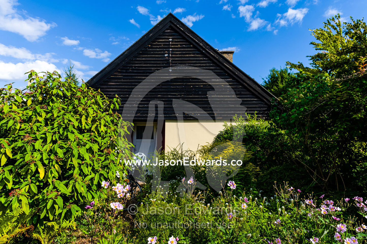 The pitched roof of a house surrounded by a cottage garden. Humlebaek, Copenhagen, Denmark.