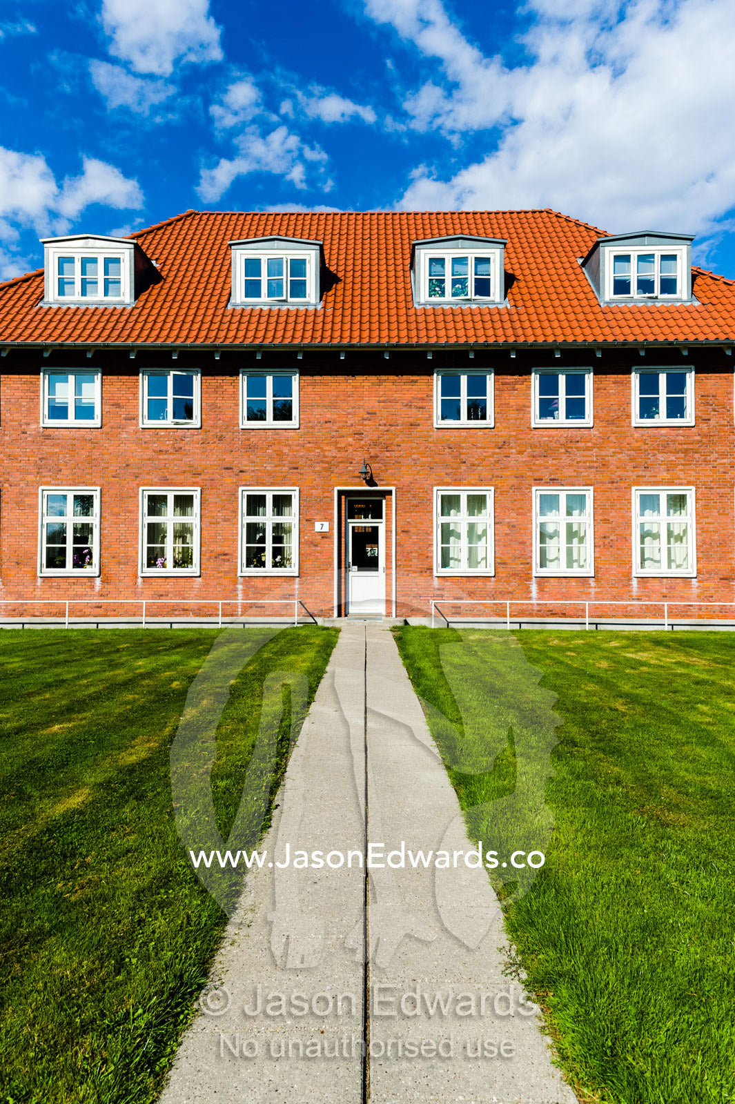 Orange brick and tiled apartments for elderly residents surrounded by manicured lawns. Humlebaek, Copenhagen, Denmark.