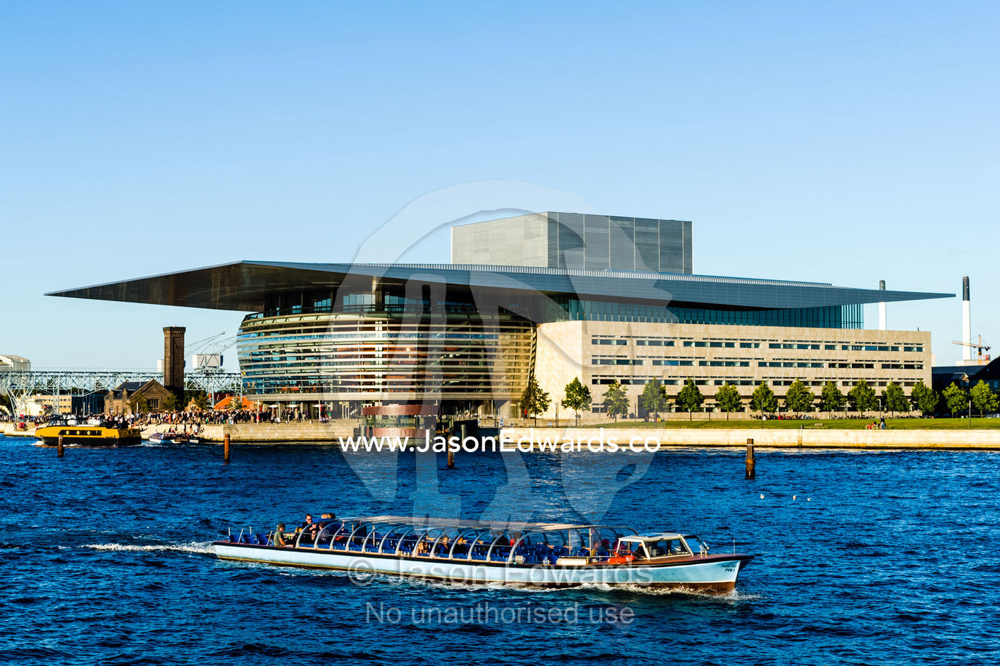 A canal boat carries tourists past the Copenhagen Opera House on a tour. Copenhagen Opera House, Holmen, Copenhagen, Denmark.