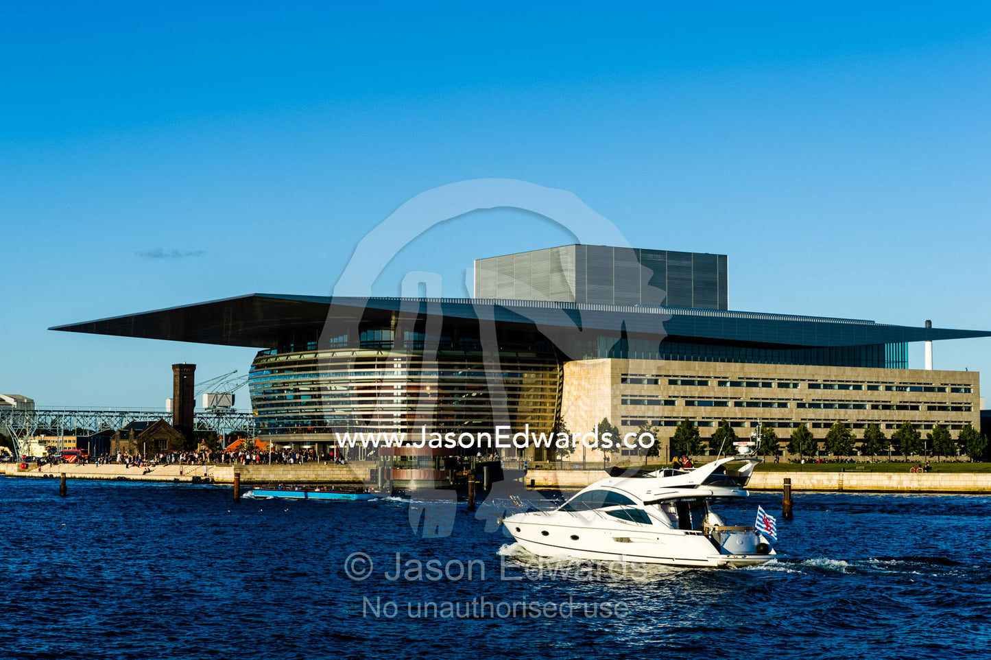 A cruise boat carries tourists past the Copenhagen Opera House on a tour. Copenhagen Opera House, Holmen, Copenhagen, Denmark.