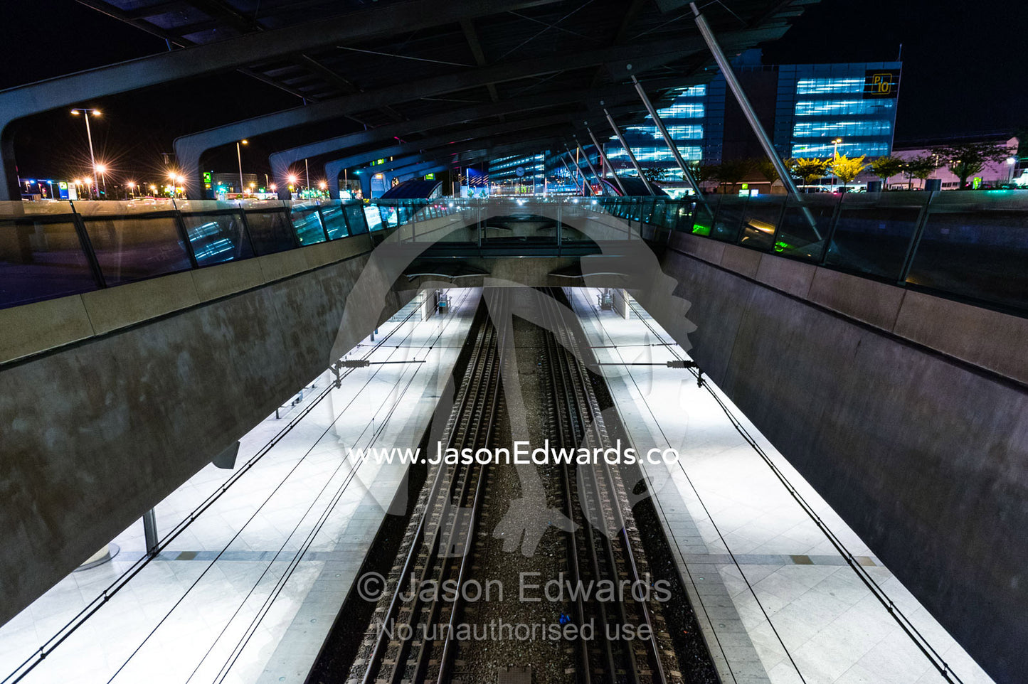 Looking down on railway tracks running between concrete platforms at a train station. Copenhagen, Denmark.