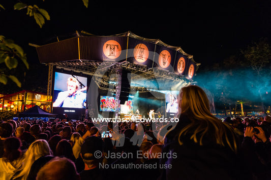 An enormous crowd watching a concert on stage and on giant LED screens. Tivoli Gardens, Copenhagen, Denmark.