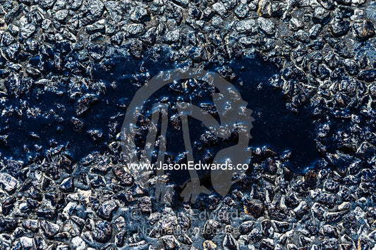 A pool of bitumen melted on a road during a hot Australian summer. Sturt Highway, New South Wales, Australia.