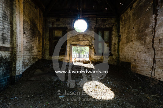 Sunlight enters the abandoned shell of an antique brewery in a rural town. Narrandera, New South Wales, Australia.