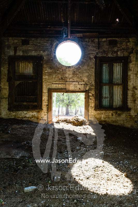 Sunlight enters the abandoned shell of an antique brewery in a rural town. Narrandera, New South Wales, Australia.