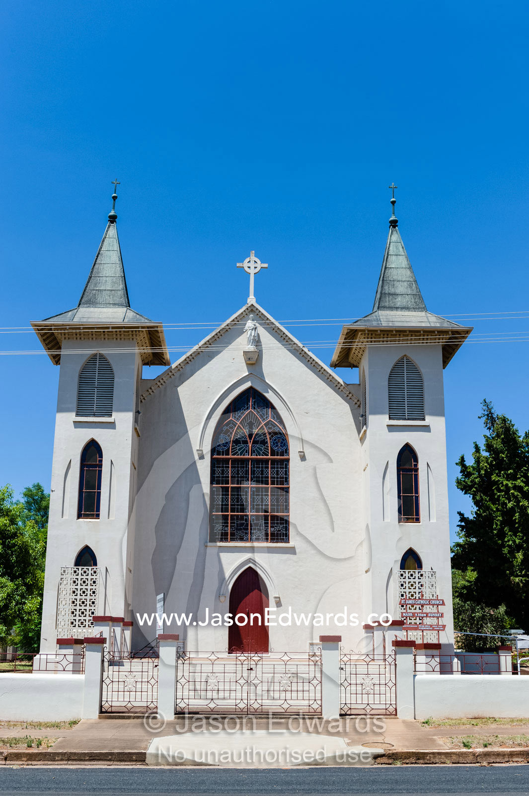 The facade and steeples of a catholic church in a rural town. Peak Hill, New South Wales, Australia.