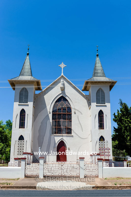 The facade and steeples of a catholic church in a rural town. Peak Hill, New South Wales, Australia.