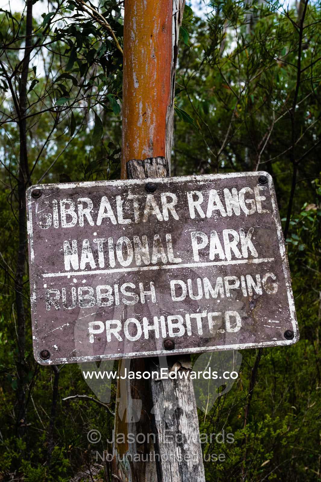 A weathered sign warns of rubbish dumping. Gibraltar Range National Park, New South Wales, Australia.