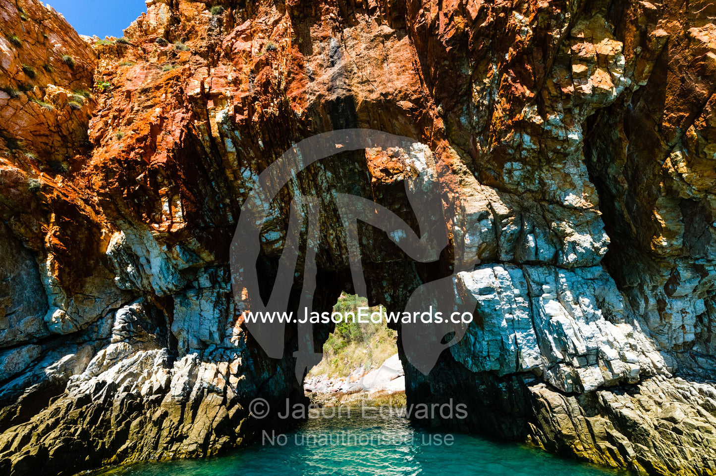 Wave motion erosion in a sandstone cliff forms a cave. Yampi Sound, Buccaneer Archipelego, Kimberley Coast, Western Australia, Australia.