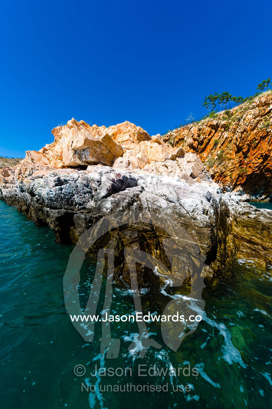 Tide marks and bird guano on a sandstone spit in the ocean. Yampi Sound, Buccaneer Archipelego, Kimberley Coast, Western Australia, Australia.