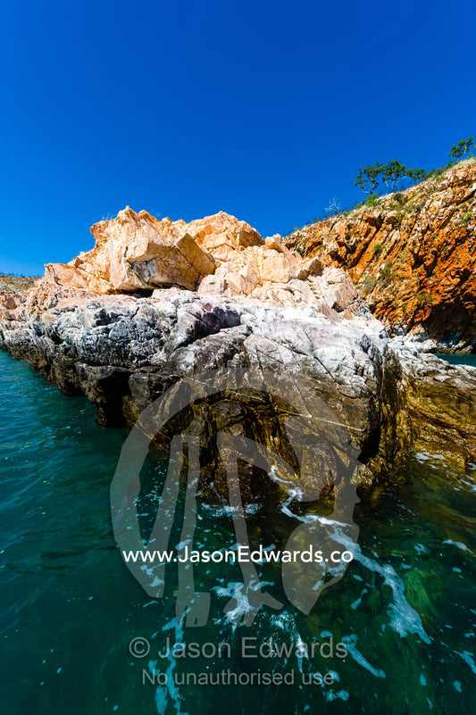 Tide marks and bird guano on a sandstone spit in the ocean. Yampi Sound, Buccaneer Archipelego, Kimberley Coast, Western Australia, Australia.