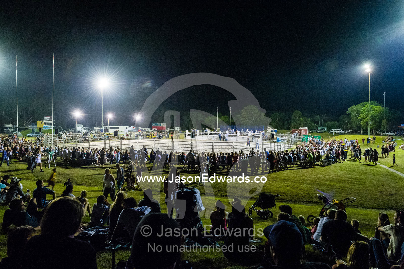 Crowds gather around an arena to watch a rodeo. Byron Bay, New South Wales, Australia.