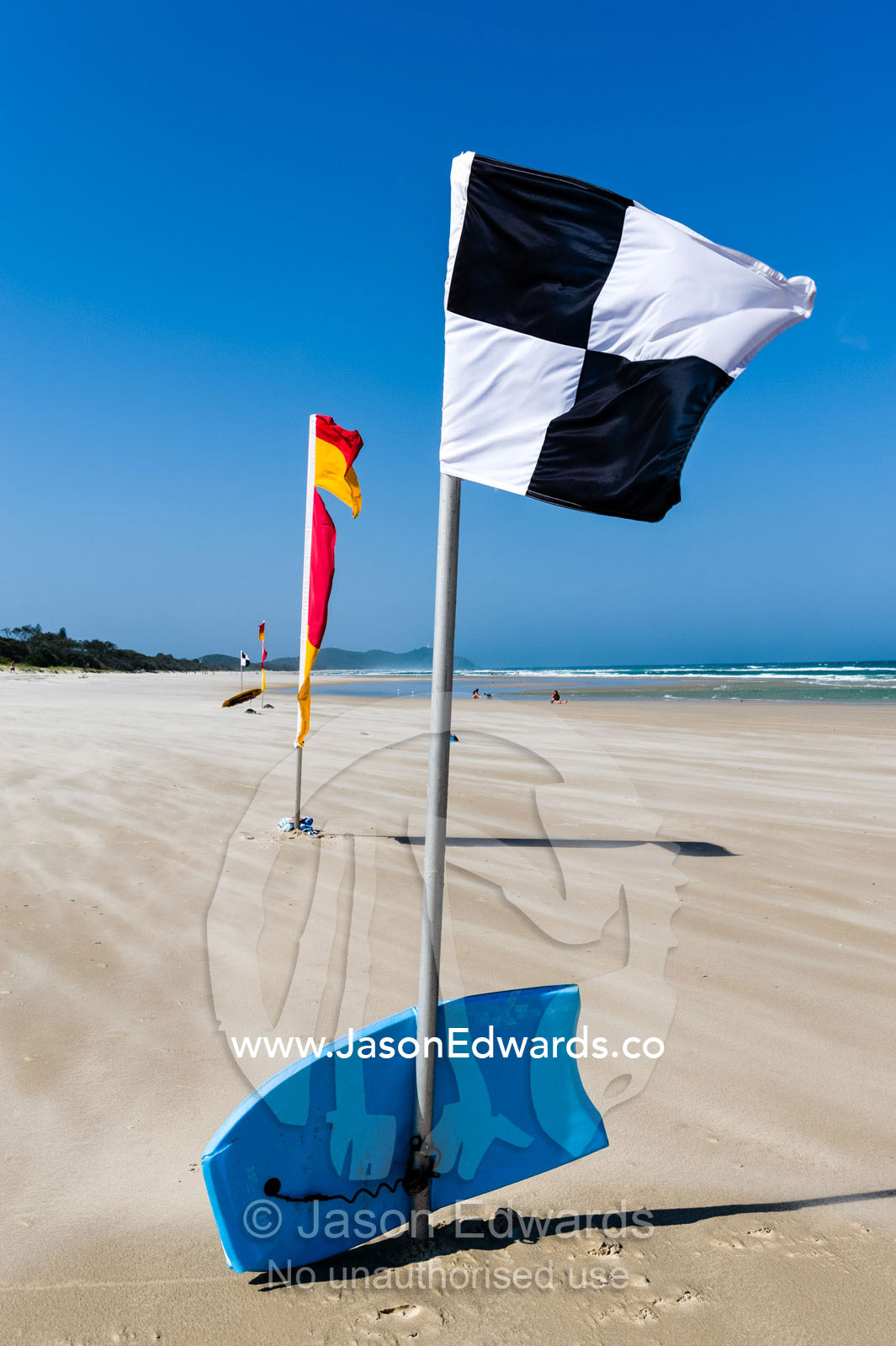 A lifesaving beach flag identifies the surf rescue craft boundary zone. Byron Bay, New South Wales, Australia.