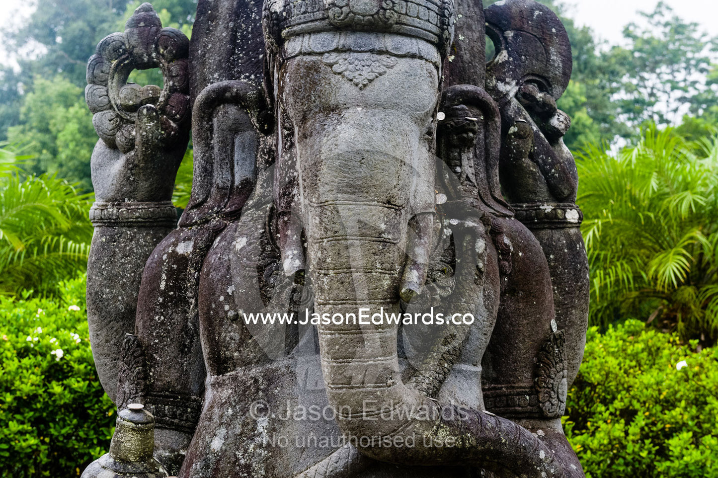 A weathered statue of Ganesh with his elephant head, trunk and tusks. Crystal Castle, Shambhala Gardens, Mullumbimby, New South Wales, Australia.