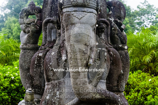 A weathered statue of Ganesh with his elephant head, trunk and tusks. Crystal Castle, Shambhala Gardens, Mullumbimby, New South Wales, Australia.