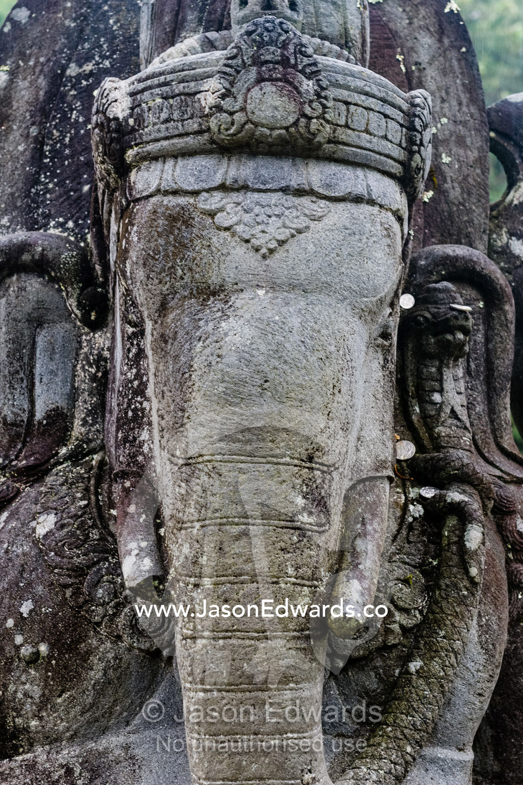 A weathered statue of Ganesh with his elephant head, trunk and tusks. Crystal Castle, Shambhala Gardens, Mullumbimby, New South Wales, Australia.