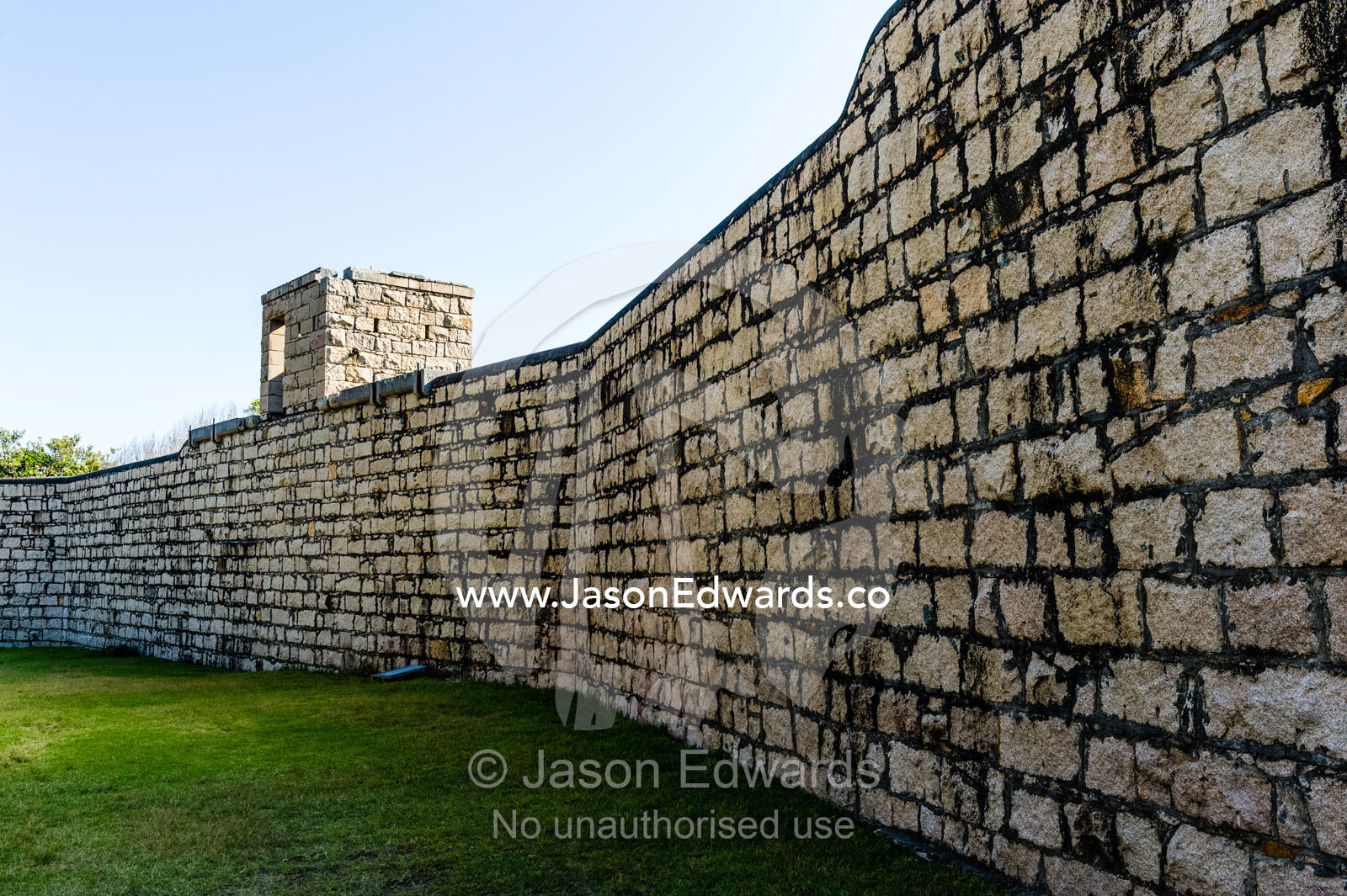 A high limestone moat wall prevented prisoners from escaping an antique prison. Trial Bay Goal, Laggers Point, Arakoon National Park, New South Wales, Australia.