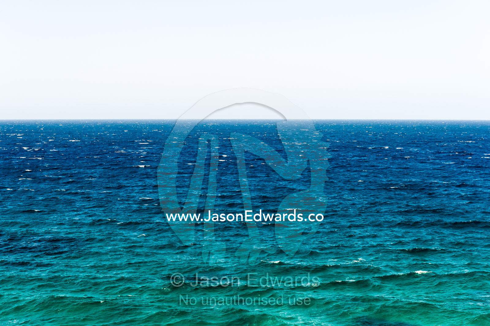 The wind-blown surface and horizon of a turquoise ocean. Trial Bay Goal, Laggers Point, Arakoon National Park, New South Wales, Australia.