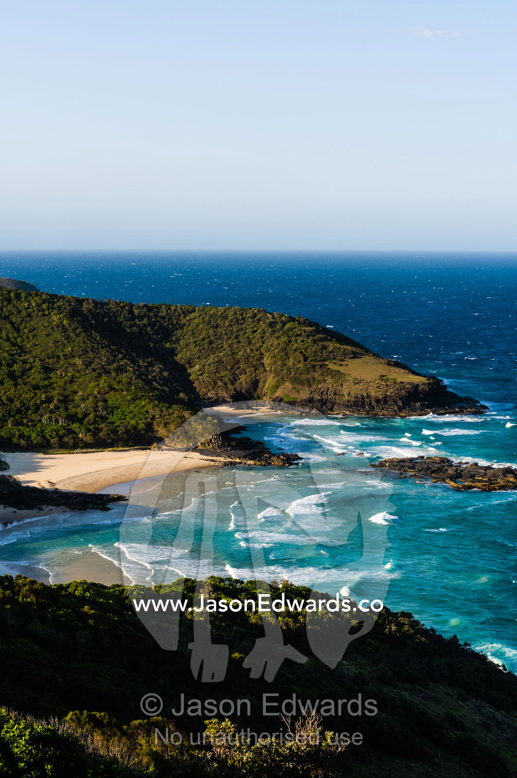 Uninhabited and pristine beaches beneath mountain forests on a rugged coastline. Smoky Cape Lighthouse, Hat Head National Park, New South Wales, Australia.