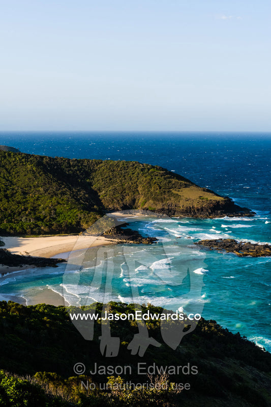 Uninhabited and pristine beaches beneath mountain forests on a rugged coastline. Smoky Cape Lighthouse, Hat Head National Park, New South Wales, Australia.