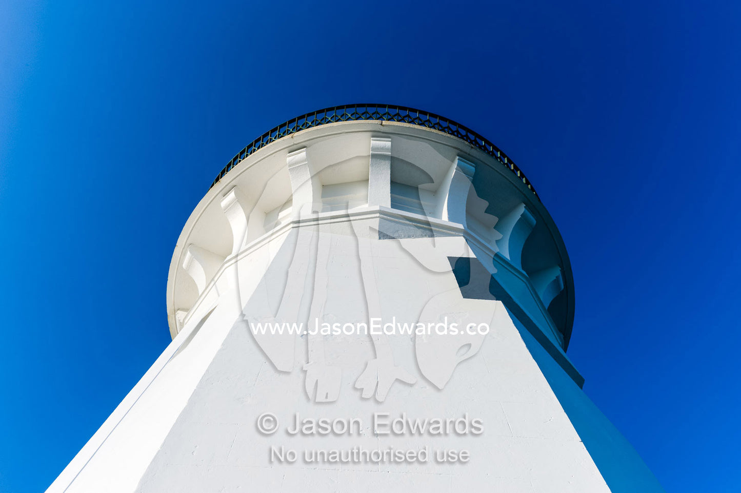 Looking skyward up the tower of a white lighthouse. Smoky Cape Lighthouse, Hat Head National Park, New South Wales, Australia.