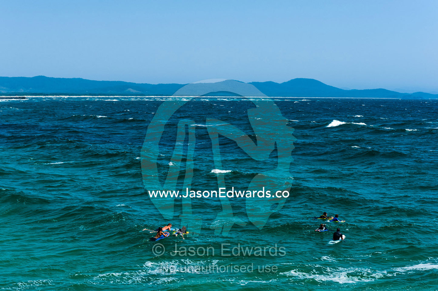 Surfers and body boarders waiting for waves in the ocean. South West Rocks, New South Wales, Australia.