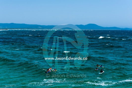 Surfers and body boarders waiting for waves in the ocean. South West Rocks, New South Wales, Australia.