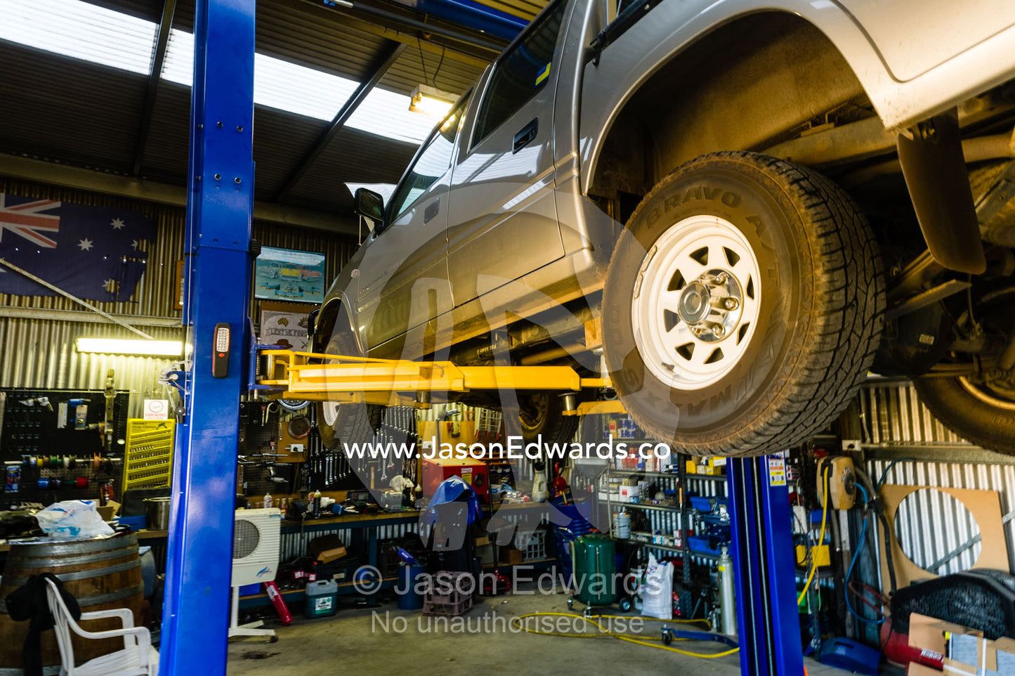 A 4wd on a high lift jack in a farm workshop. Holbrook, New South Wales, Australia.
