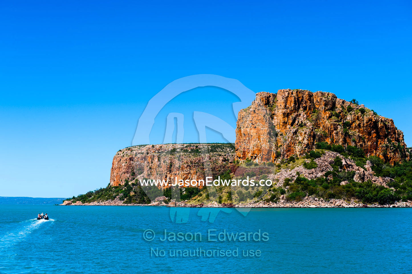 A zodiac carries tourists to explore an enormous sandstone headland. Raft Point, Doubtful Bay, Buccaneer Archipelago, Kimberley Coast, Western Australia, Australia.