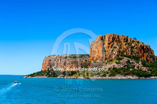 A zodiac carries tourists to explore an enormous sandstone headland. Raft Point, Doubtful Bay, Buccaneer Archipelago, Kimberley Coast, Western Australia, Australia.