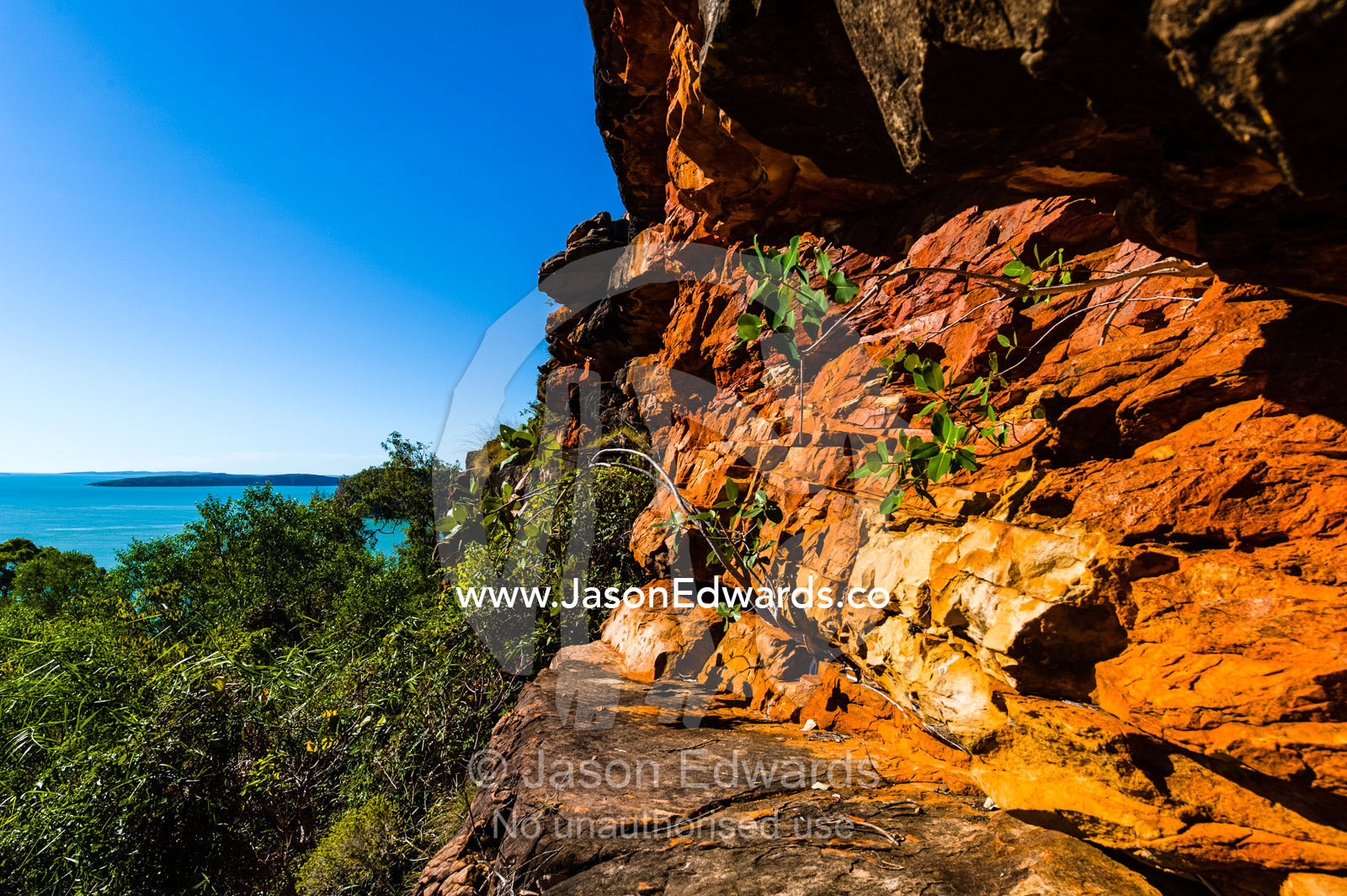 An ochre sandstone cliff overlooking the rich turquoise ocean. Raft Point, Doubtful Bay, Buccaneer Archipelago, Kimberley Coast, Western Australia, Australia.