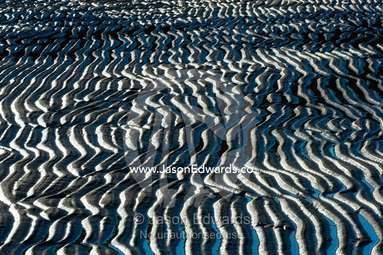 Sand patterns wave and snake their way across a beach at low tide. Calamity Bay, Koolama Bay, Kimberley Coast, Western Australia, Australia.