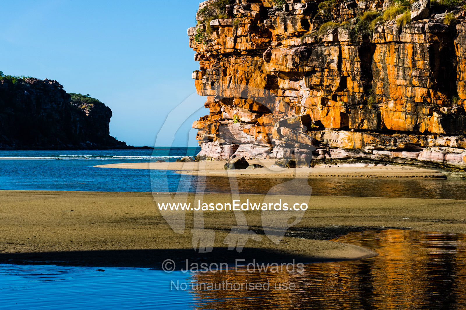 Sandstone cliffs on a remote and pristine coastal desert beach. Calamity Bay, Koolama Bay, Kimberley Coast, Western Australia, Australia.