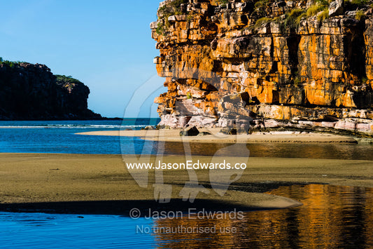 Sandstone cliffs on a remote and pristine coastal desert beach. Calamity Bay, Koolama Bay, Kimberley Coast, Western Australia, Australia.