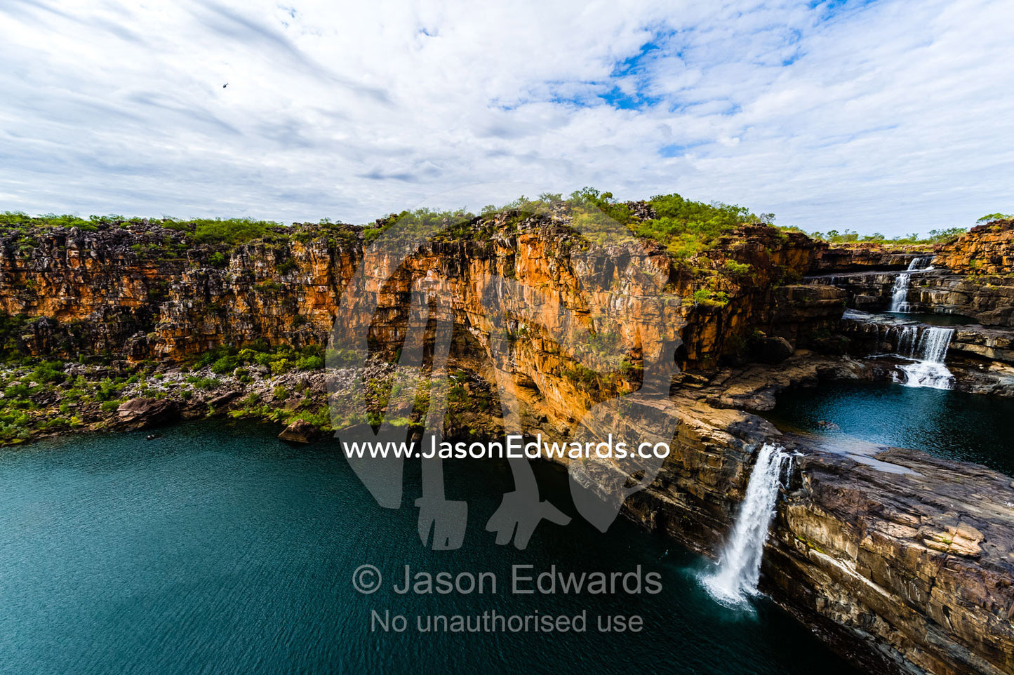 The magnificent Mitchell River cascades down ochre sandstone tiers in multiple waterfalls. Mitchell Falls, Mitchell River National Park, Mitchell Plateau, Kimberley Coast, Western Australia, Australia.