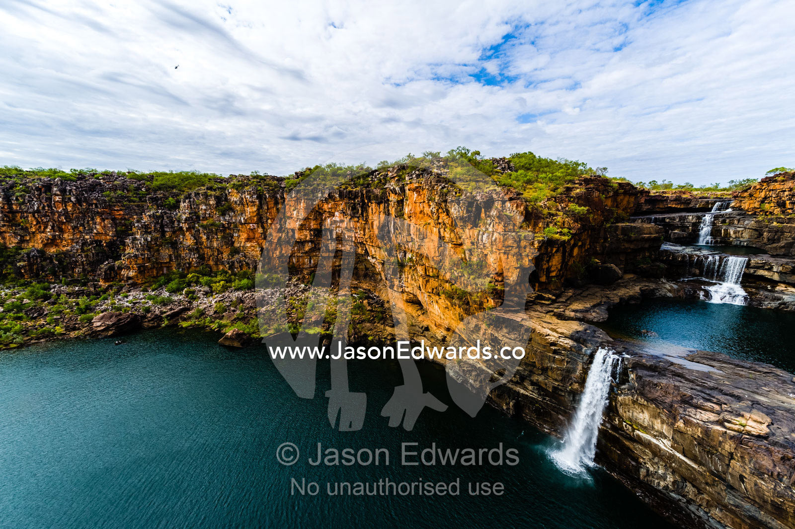 The magnificent Mitchell River cascades down ochre sandstone tiers in multiple waterfalls. Mitchell Falls, Mitchell River National Park, Mitchell Plateau, Kimberley Coast, Western Australia, Australia.
