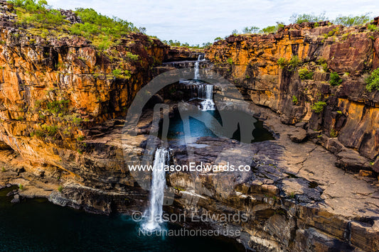The magnificent Mitchell River cascades down ochre sandstone tiers in multiple waterfalls. Mitchell Falls, Mitchell River National Park, Mitchell Plateau, Kimberley Coast, Western Australia, Australia.