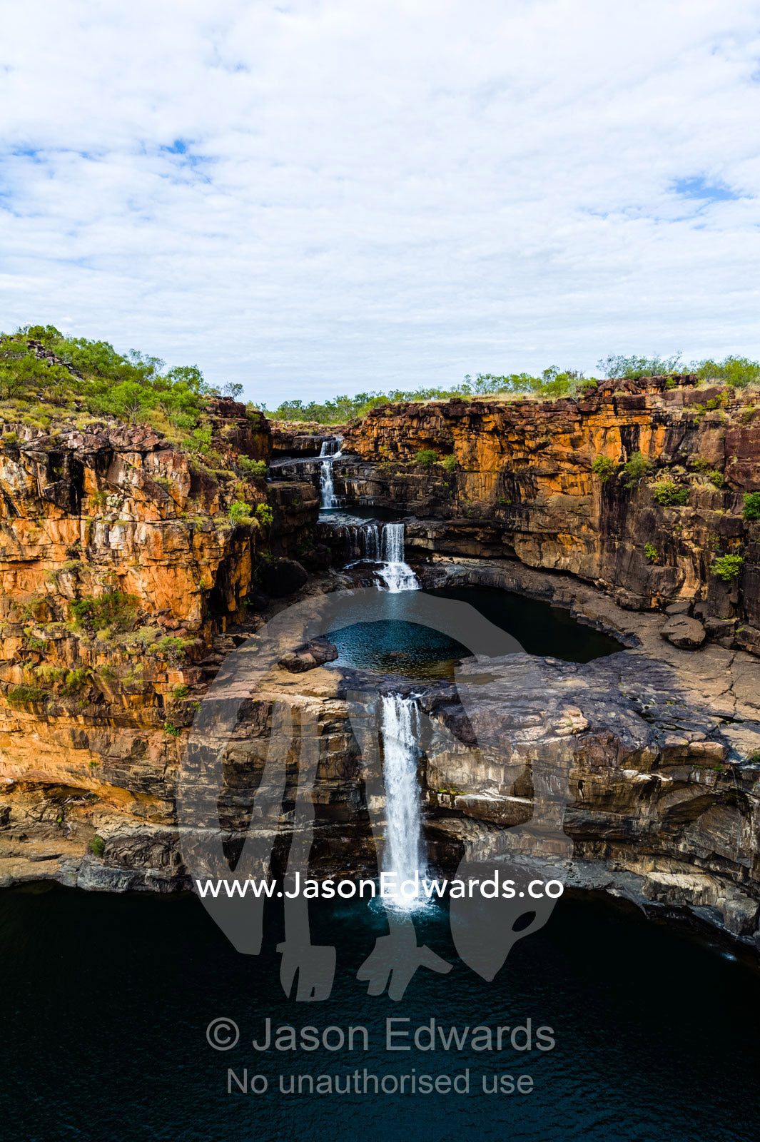 The magnificent Mitchell River cascades down ochre sandstone tiers in multiple waterfalls. Mitchell Falls, Mitchell River National Park, Mitchell Plateau, Kimberley Coast, Western Australia, Australia.