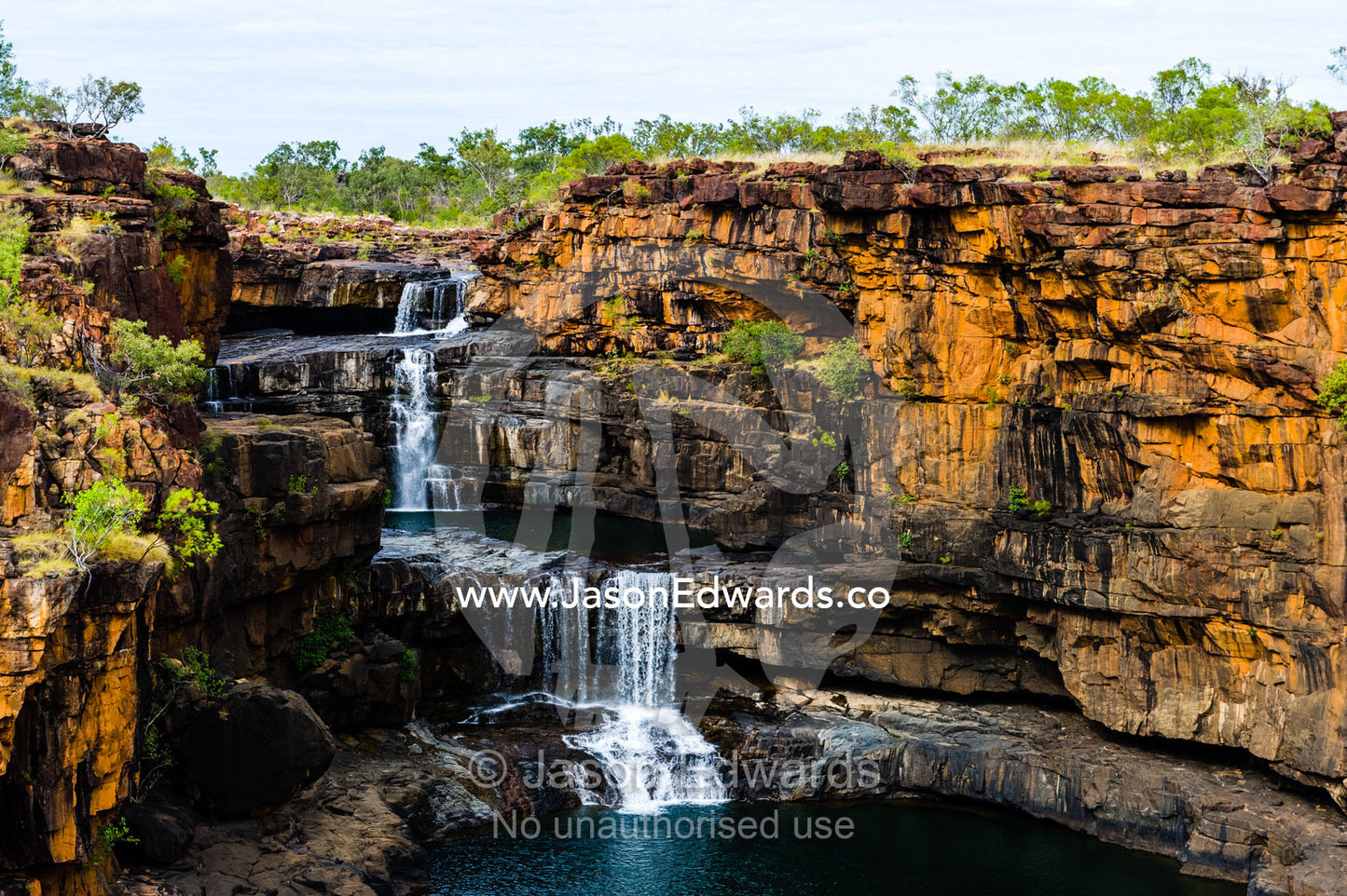 The magnificent Mitchell River cascades down ochre sandstone tiers in multiple waterfalls. Mitchell Falls, Mitchell River National Park, Mitchell Plateau, Kimberley Coast, Western Australia, Australia.