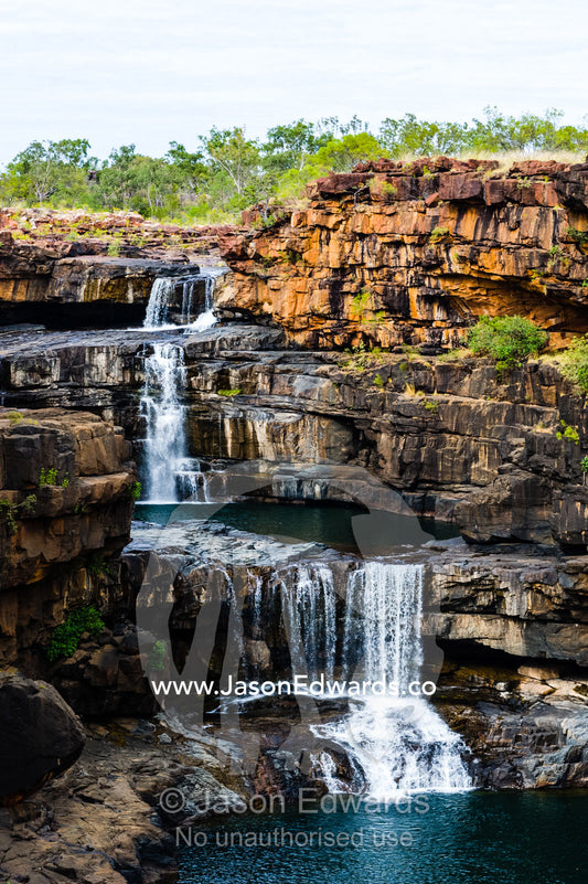 The magnificent Mitchell River cascades down ochre sandstone tiers in multiple waterfalls. Mitchell Falls, Mitchell River National Park, Mitchell Plateau, Kimberley Coast, Western Australia, Australia.
