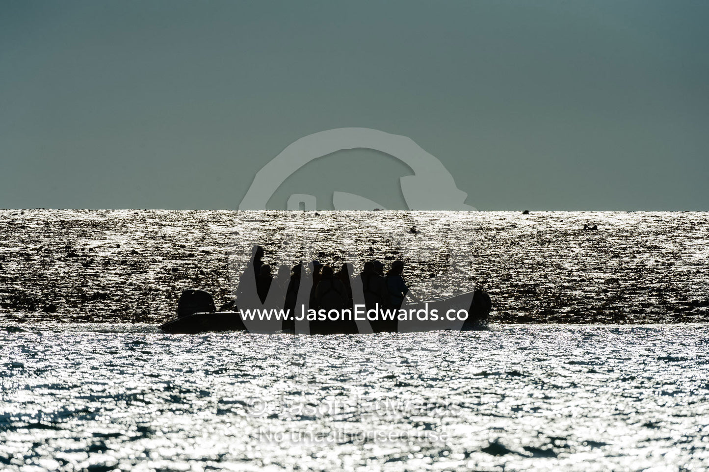 The silhouette of an inflatable zodiac with tourists exploring an exposed reef at low tide. Montgomery Reef, Camden Sound, Kimberley Coast, Western Australia, Australia.