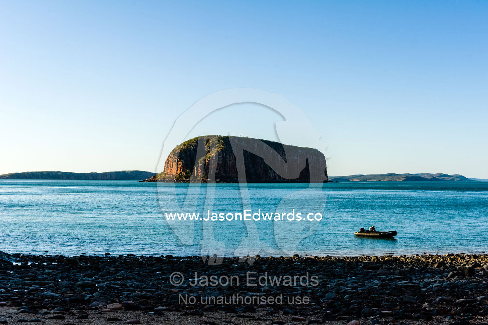 A solitary dingy on the shore if an uninhabited beach at sunset. Raft Point, Doubtful Bay, Buccaneer Archipelago, Kimberley Coast, Western Australia, Australia.