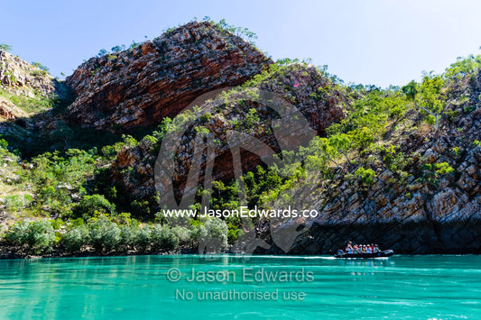 Tourists in a dingy explore the geology of a desert gorge on the Kimberley Coast. Cyclone Bay, Buccaneer Archipelago, Kimberley Coast, Western Australia, Australia.