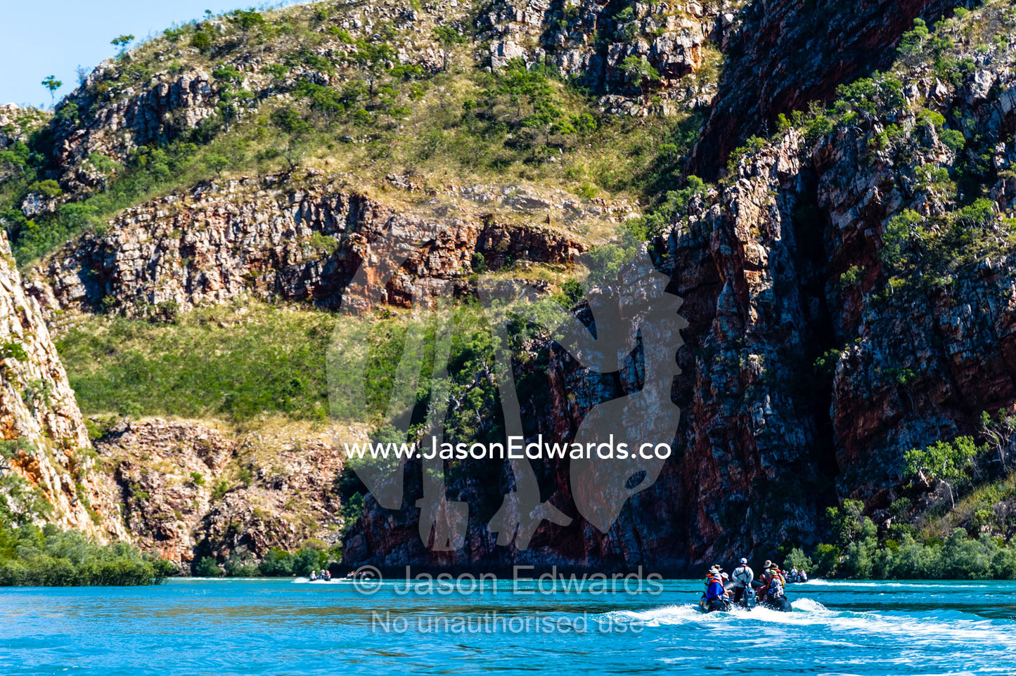 Tourists in a dingy explore the geology of a desert gorge on the Kimberley Coast. Cyclone Bay, Buccaneer Archipelago, Kimberley Coast, Western Australia, Australia.
