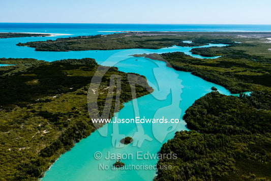 A turquoise tidal river winding it's way through mangroves in a tidal estuary. Willie Creek, Willie Creek Pearl Farm, Broome, Western Australia, Australia.
