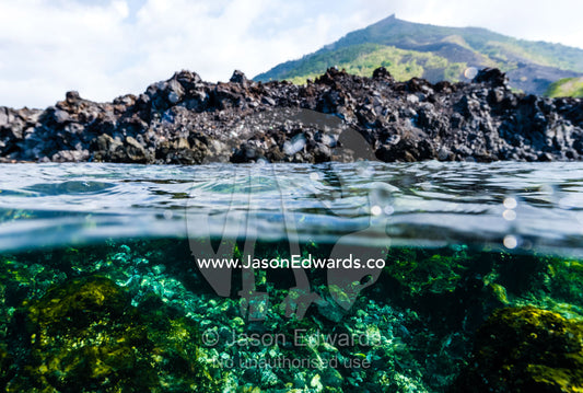 Black and barren lava which has flowed down the slope of an active volcano into the ocean. Lava Flow, Banda Neira, Banda Islands, Maluku Province, Indonesia.